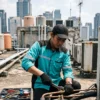 teknisi service ac sedang memperbaiki pipa ac di area jakarta